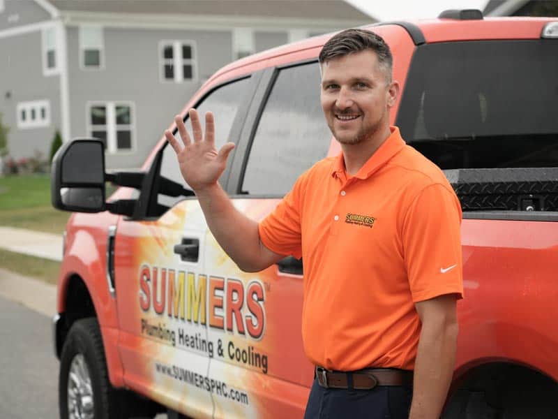 Summers PHC technician waving beside a branded service truck