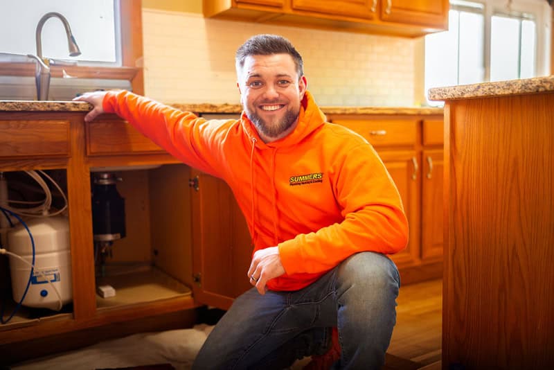 Summers PHC plumber at a kitchen sink in a Fort Wayne home