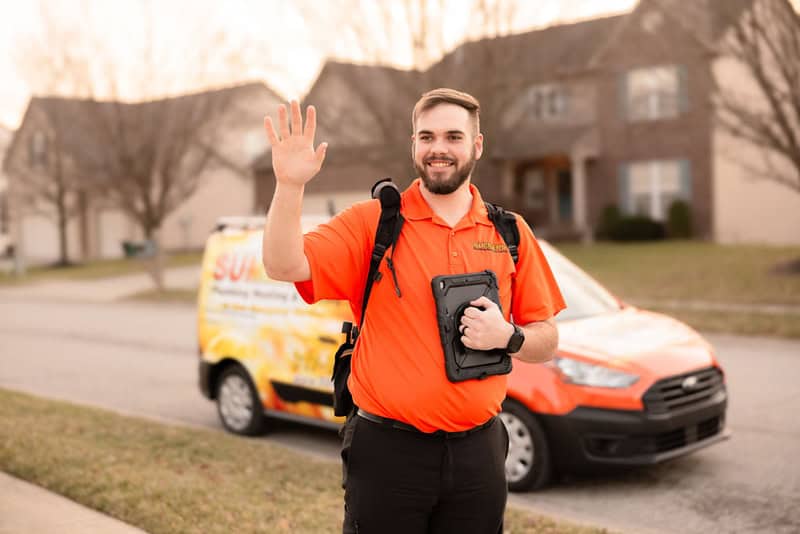 Summers PHC technician waving in front of a service van in a Crawfordsville-area neighborhood